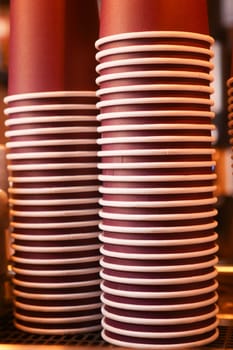 Stacks of disposable cups prepare for a busy coffee service at a cafe.