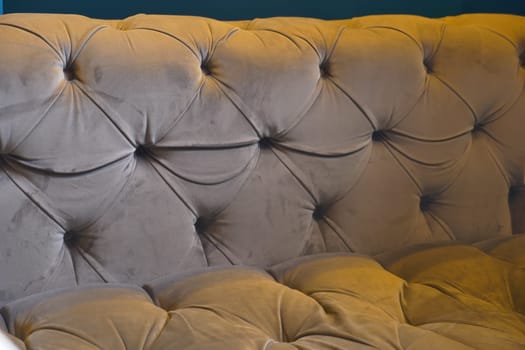 A plush tufted couch offers comfort in a warm living room space.