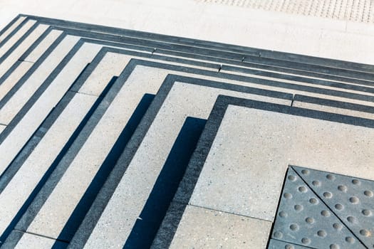 Sunlight and shadow on wide stone staircase. Abstract theme.