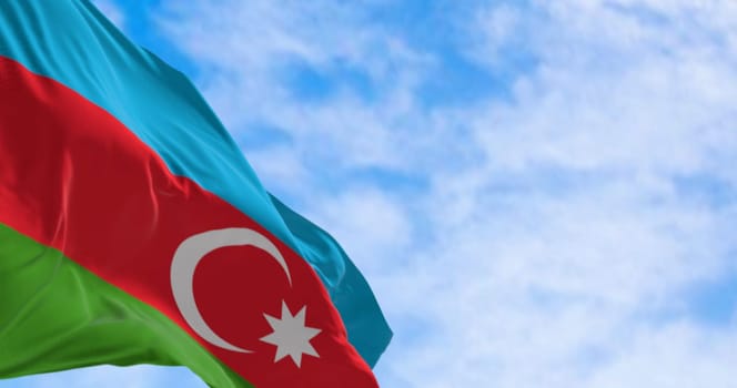 The national flag of Azerbaijan waving in the wind on a clear day. Horizontal tricolour of blue, red, green with a white crescent and star. 3D illustration render. Rippled textile