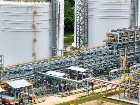 Industrial oil refinery with complex network of steel pipelines and massive storage tanks. Petrochemical plant producing fuel energy. Modern industrial infrastructure for petroleum processing.