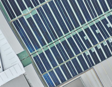 Solar energy system installed on the rooftop of an industrial factory and warehouse. Clean and renewable power solutions, green energy innovation, and sustainable commercial electricity generation.