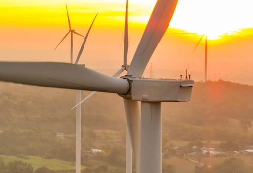 Wind farm field and sunset sky. Wind power. Sustainable, renewable energy. Wind turbines generate electricity. Sustainable development. Green technology for energy sustainability. Eco-friendly energy.