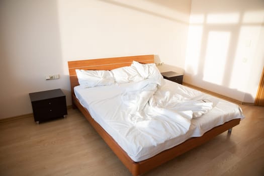 Empty bed with linen in the bedroom in the morning