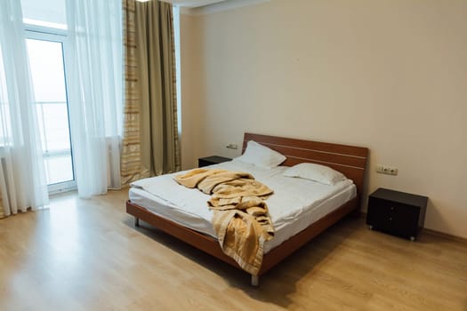 Empty bed with linen in the bedroom in the morning