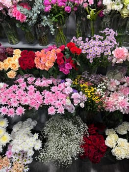 Many different colors on the shelves of the florist's store