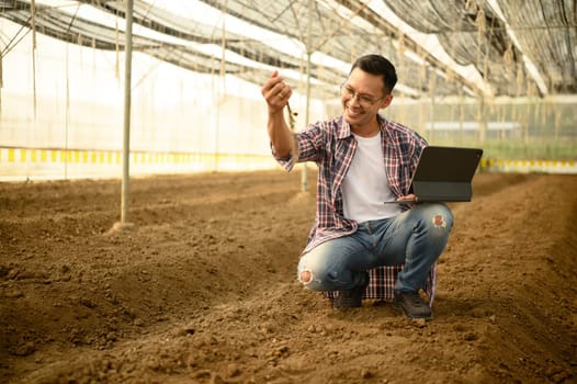 Male agronomist using digital tablet for data analysis inside a in greenhouse.