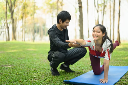 Active young couple practicing yoga together outdoors.