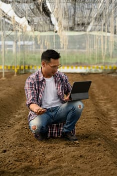 Male agronomist using digital tablet for data analysis inside a in greenhouse.