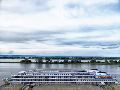 Bolgar, Russia - August 04, 2024: A cruise ship is anchored at the dock in Bolgar, Russia, offering a view of the tranquil river and surrounding greenery.