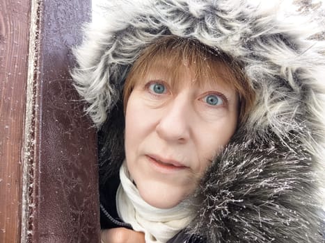 Blonde woman captures a selfie while exploring a snowy destination, showcasing her love for travel and adventure in winter.