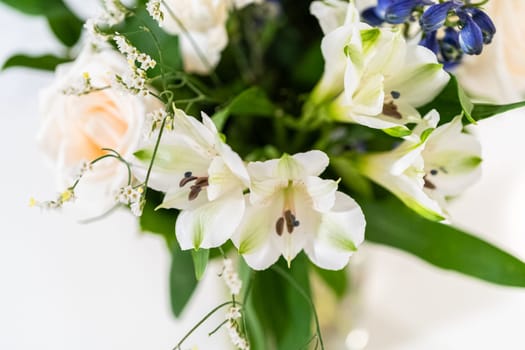 A stunning bouquet featuring fresh white roses and assorted flowers gracefully arranged in a vase, exuding timeless beauty.