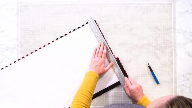 Flat lay. In the process of mounting peel and stick mosaic tiles onto a foam board, perfect for enhancing a food photography studio's aesthetic.