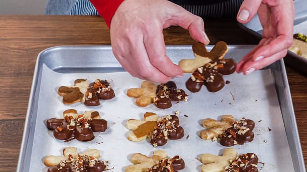 Carefully packaging Christmas cutout cookies, half-dipped in chocolate and presented in clear cellophane wrapping, perfect for festive gifting.
