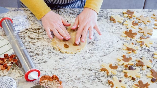 Using an adjustable rolling pin to roll out gingerbread cookie dough on the elegant marble counter in a modern kitchen, getting ready for festive holiday baking.