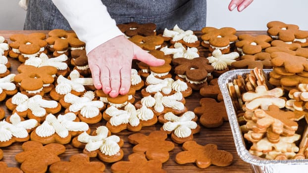 Crafting gingerbread cookie sandwiches with eggnog buttercream, presented on a rustic wooden table for Christmas gifting.