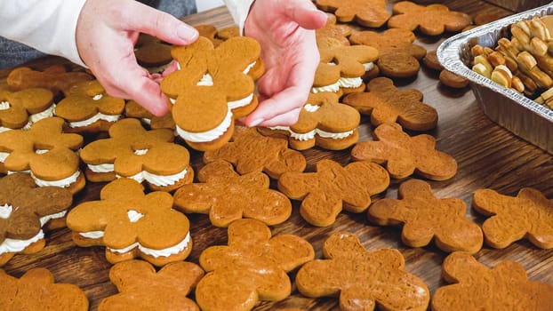 Crafting gingerbread cookie sandwiches with eggnog buttercream, presented on a rustic wooden table for Christmas gifting.