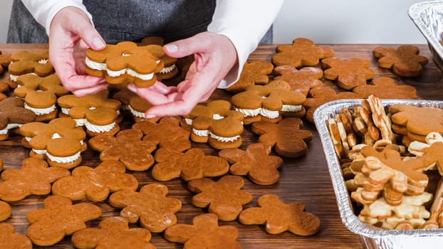 Crafting gingerbread cookie sandwiches with eggnog buttercream, presented on a rustic wooden table for Christmas gifting.