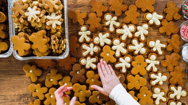 Flat lay. Crafting gingerbread cookie sandwiches with eggnog buttercream, presented on a rustic wooden table for Christmas gifting.