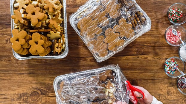 Flat lay. Uwrapping frozen gingerbread cookie to decorate for food gifting for Christmas.
