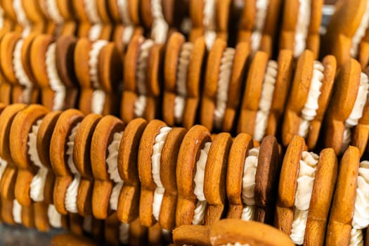 Making gingerbread man cookie sandwiches filled with eggnog buttercream, arrayed on a rustic wooden table, ideal for heartfelt Christmas gifting.