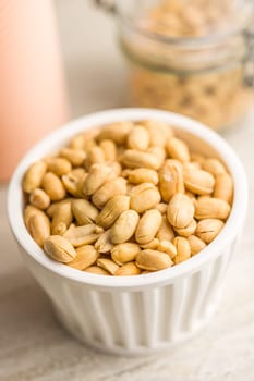 Roasted salted peanuts in bowl on a kitchen table