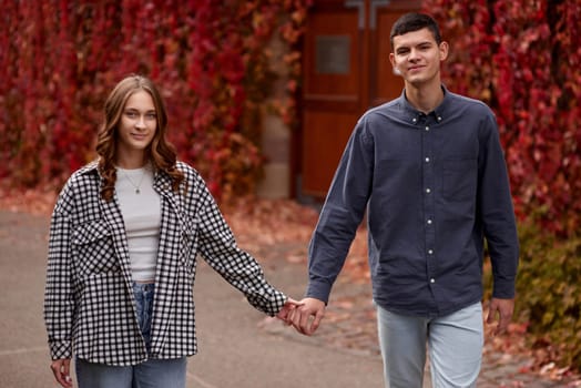 Young Cute Female Hugs Boyfriend. In Autumn Outdoor. Lovers Walking in Park. Attractive Funny Couple. Lovestory in Forest. Man and Woman. Cute Lovers in the Park. Family Concept. Happy Couple.