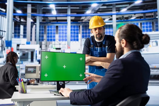 Solar panels plant engineering team doing quality control using green screen computer, ensuring high efficiency. Photovoltaics factory coworkers calibrating assembly lines robotic arms on mockup PC