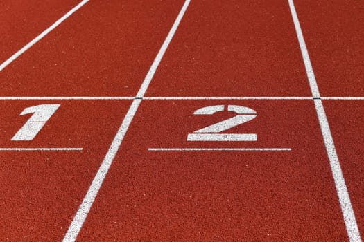 The red runway is numbered in a stadium