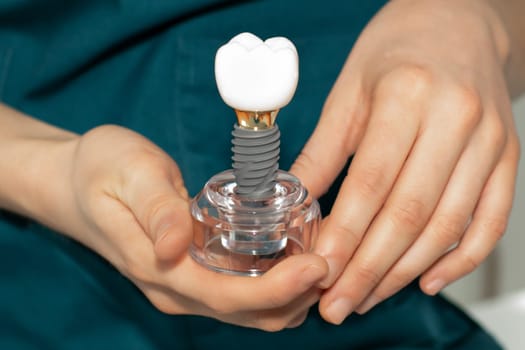 Dentist prosthetist holding a dental implant in his hands