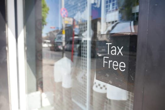 A shop window displays a sign promoting tax-free shopping in the city.