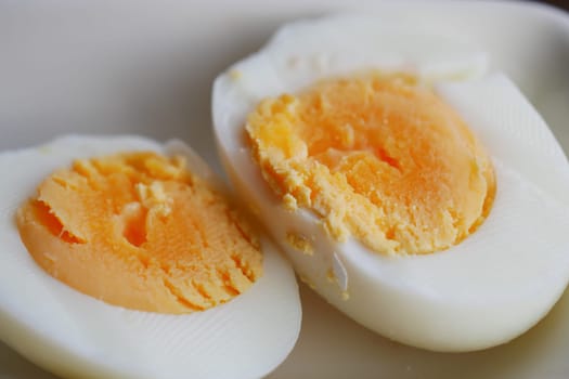 Soft-boiled eggs cut in half reveal creamy yolks, served on a plate.
