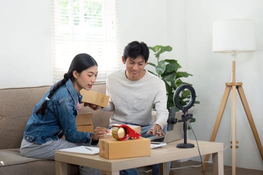 The couple collaborates on their business strategy at their home office, excitedly sharing ideas and reviewing their latest shipments of products while surrounded by packed boxes.