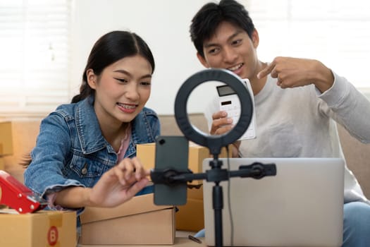 A couple records a video while discussing their business strategy for an online store, showcasing their entrepreneurial spirit and engaging digital presence.