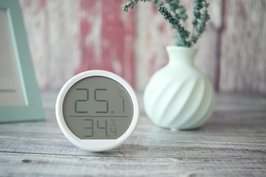 A temperature and humidity display shows readings next to a decorative vase.