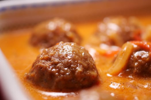 Juicy meatballs cook in a flavorful sauce with vegetables and spices.