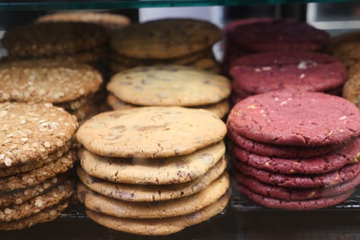 A variety of cookies in different flavors are stacked neatly for customers.