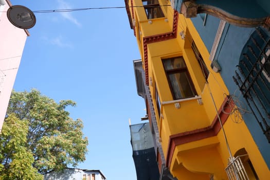 Bright yellow building stands out under a sunny sky with sparse clouds.