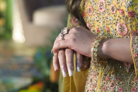 Intricate rings and a bracelet complement a beautifully designed outfit.