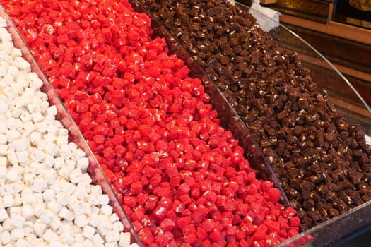 Vibrant assortment of Turkish delight varieties for sale at a market.