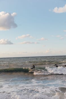 surfers on boards riding the waves in a storm