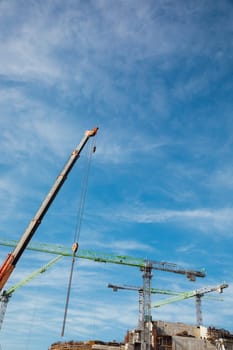 Construction cranes for building houses against sky background