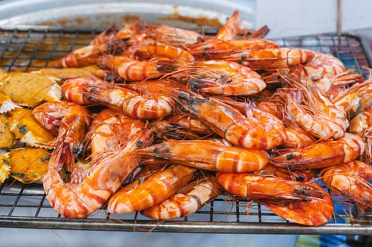 Grilled shrimps at an Asian night market in close-up. Traditional street sea food hot prawns in Asia in Vietnam