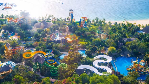 aquapark with slides and a swimming pool at resort. Entertainment park with water park by the sea on VinPearl in Nha Trang in Vietnam aerial top view from drone