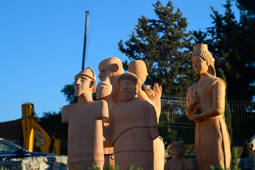 Terracotta sculptures from an ancient civilization come alive in the soft evening light. Set in a serene outdoor space, these figures reflect a rich cultural history while surrounded by nature.