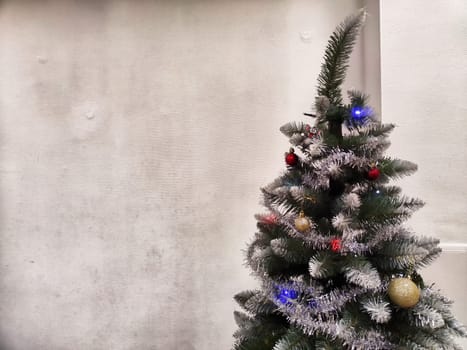 A Christmas tree adorned with shimmering decorations stands in a warm indoor space, radiating festive cheer and inviting joy.