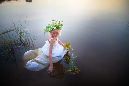 Girl in White Sundress With Flower Wreath in Water at Sunset Celebrating Ivan Kupala Holiday