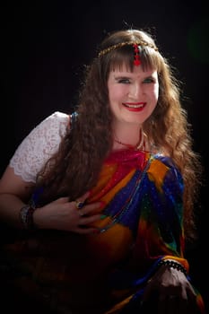 A woman with long blonde hair poses gracefully in a colorful sari, expressing her vibrant style during a creative photoshoot.