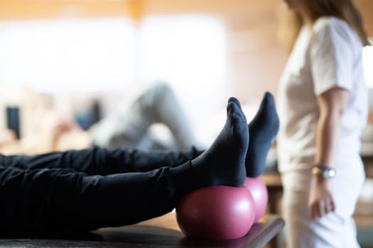 A physiotherapist treating a patients foot in a busy rehabilitation center, focusing on recovery and mobility improvement.
