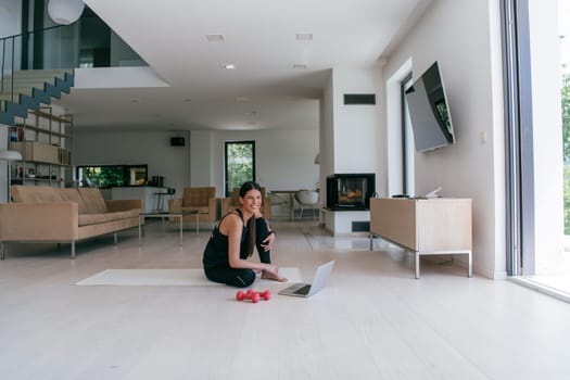 Young Beautiful Female Exercising, Stretching and Practising Yoga with Trainer via Video Call Conference in Bright Sunny House. Healthy Lifestyle, Wellbeing and Mindfulness Concept